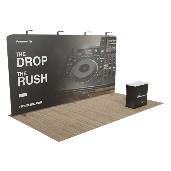 A trade show display featuring a large backdrop with a DJ mixer image and the text 'THE DROP THE RUSH Pioneer DJ pioneerdj.com,' alongside a promotional counter.